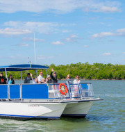 Blue and white boat on the water with group of people standing