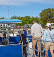 Four people walking on the dock to get onto the boat